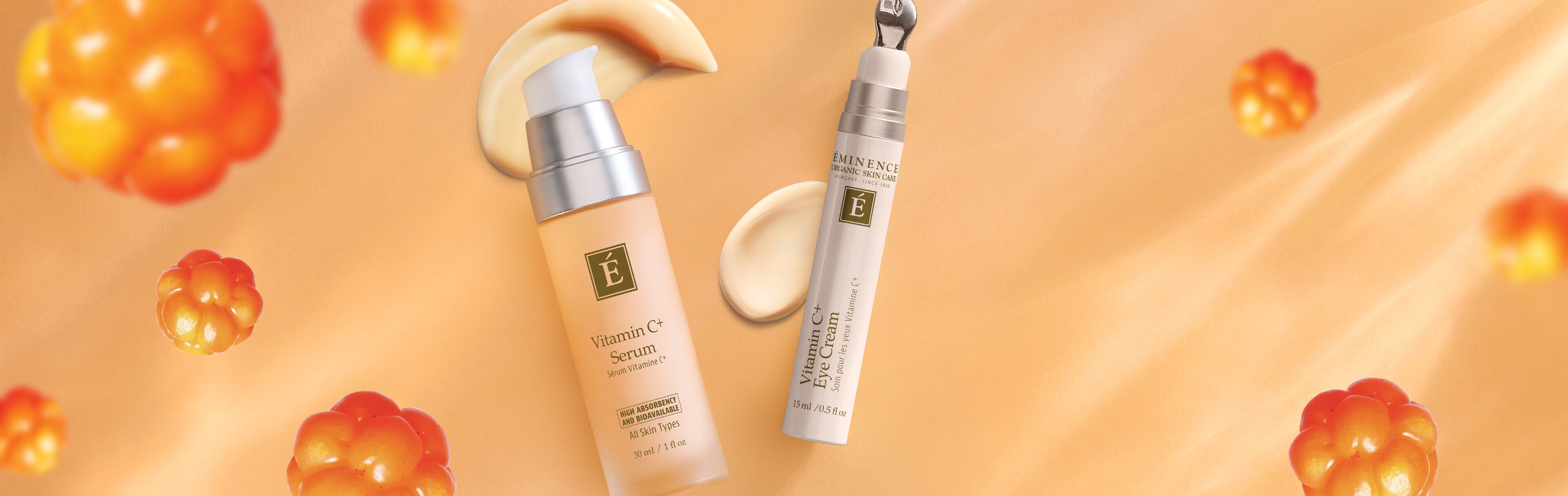 Eminence Organics Vitamin C serum and eye cream surrounded by cloudberry